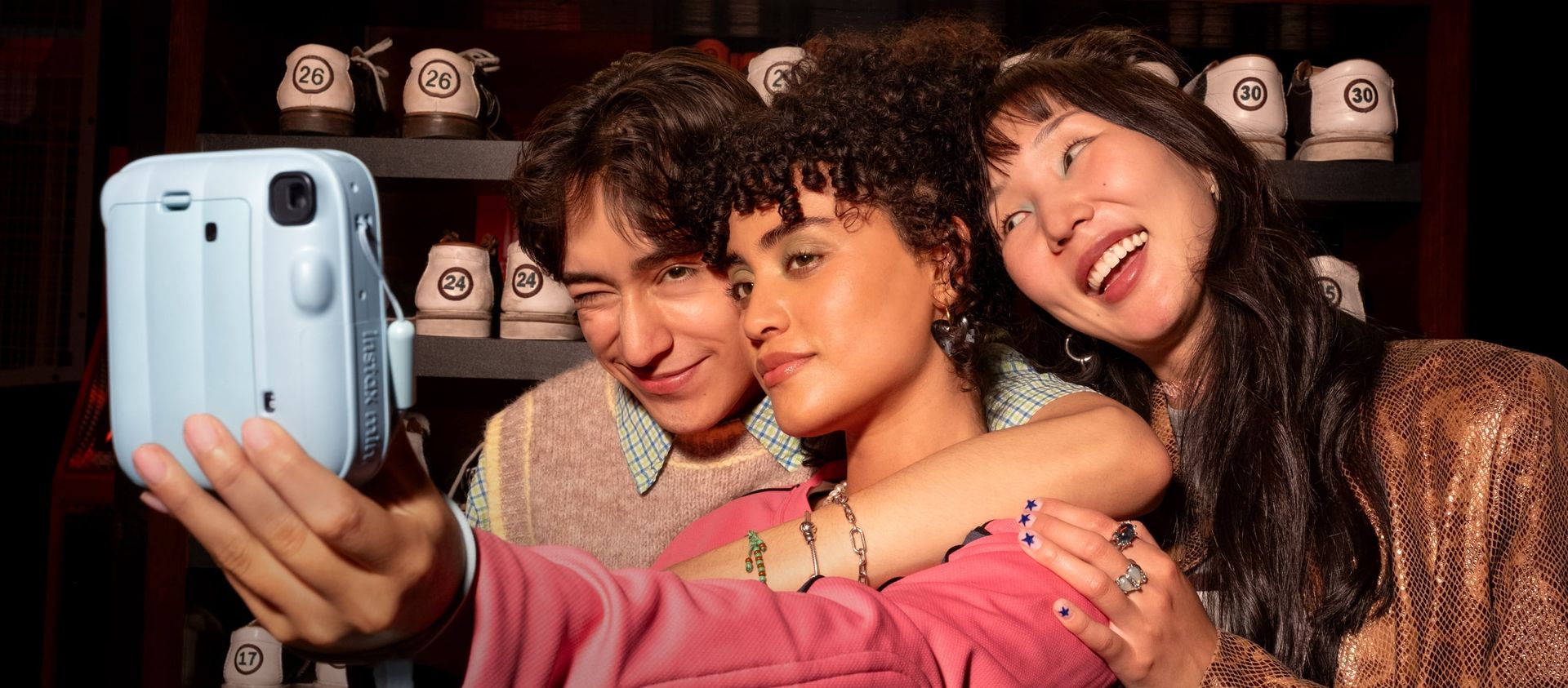 Friends taking a group selfie with the INSTAX mini 13 camera