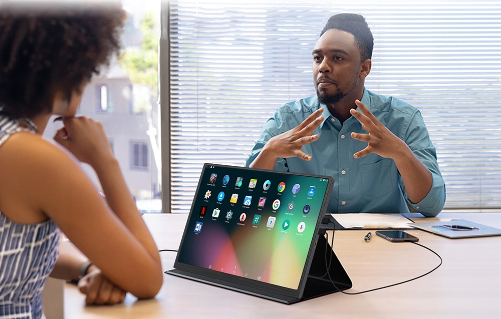 ZEUSLAP portable monitor being used on a conference table during a business meeting