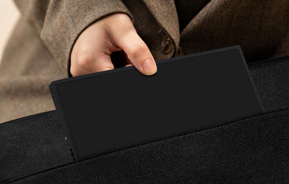 Slim ZEUSLAP portable monitor being placed into a travel bag